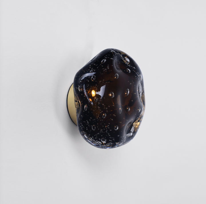 designer galaxy wall light with textured glass creating warm ambient illumination on a modern interior wall