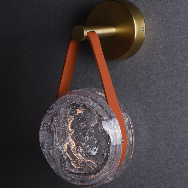 hanging crater glass wall lamp with leather strap used as modern bedside accent lighting