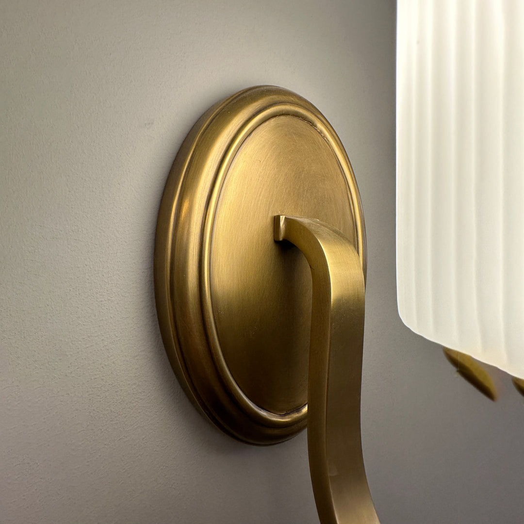 close up of brass wall lamp with fluted glass shade highlighting modern design ideal for indoor wall lighting bedrooms living rooms and refined contemporary décor