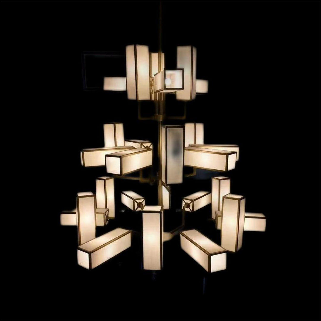Lucretia Empire chandelier illuminated on black background showing luxury brass and fabric shade pendant lighting