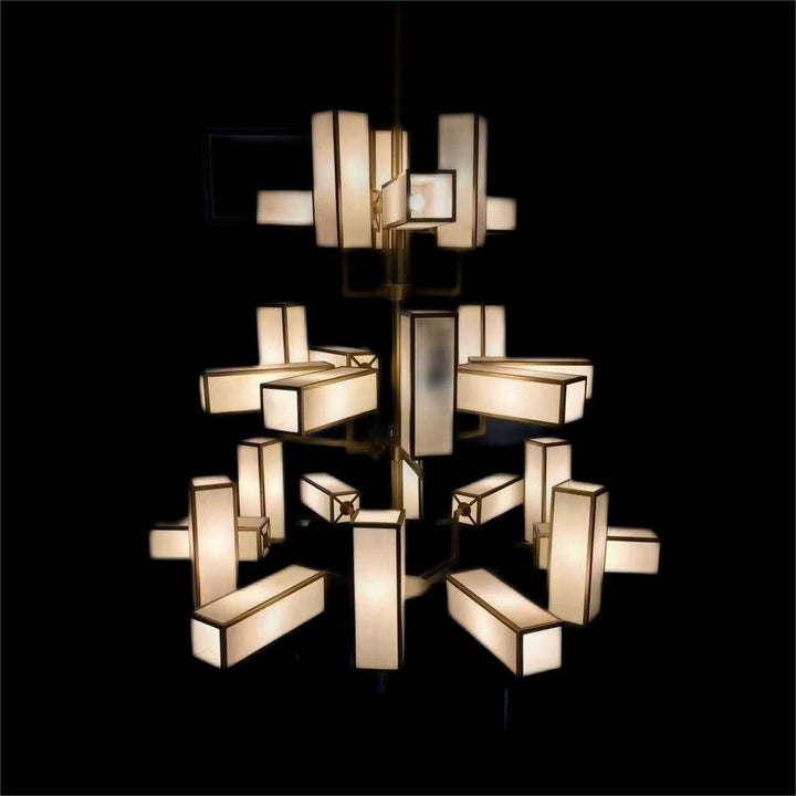 Lucretia Empire chandelier illuminated on black background showing luxury brass and fabric shade pendant lighting