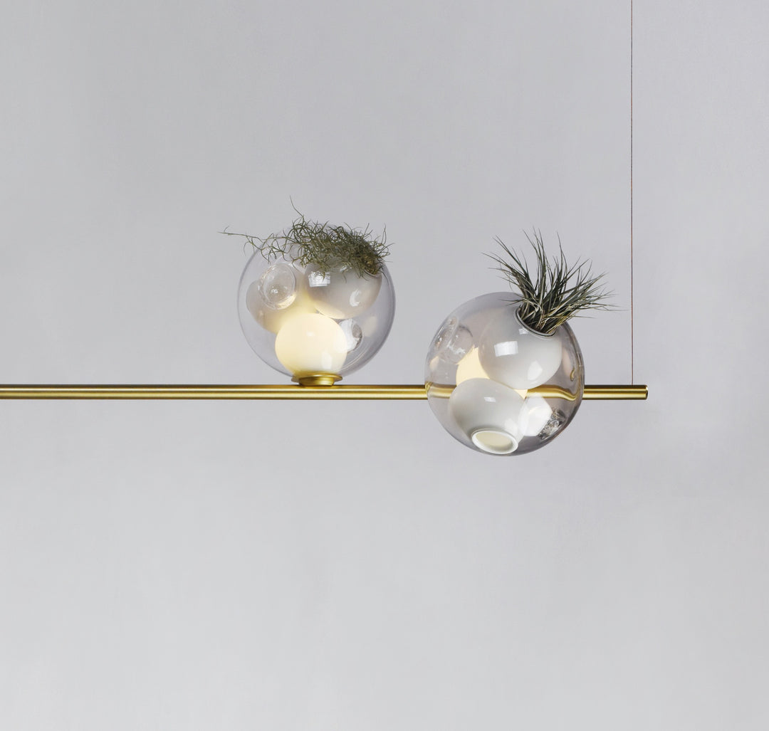 Green Linear Pendant Light by Lucretia Lighting featuring biophilic glass pods with air plants on a modern gold linear bar