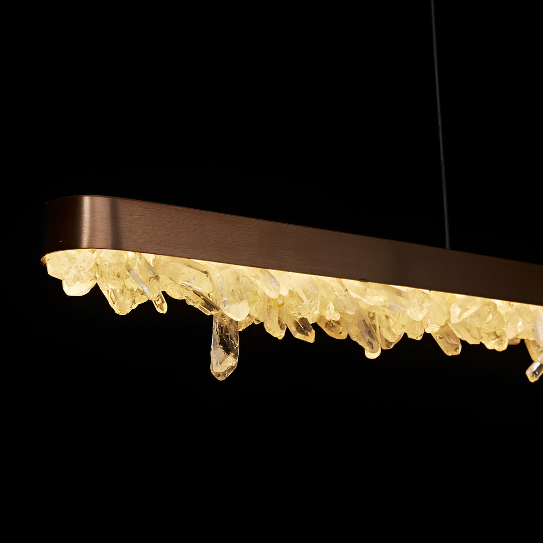 close up of Pedra de Cristal horizontal linear pendant showing raw crystal edge and warm integrated LED illumination