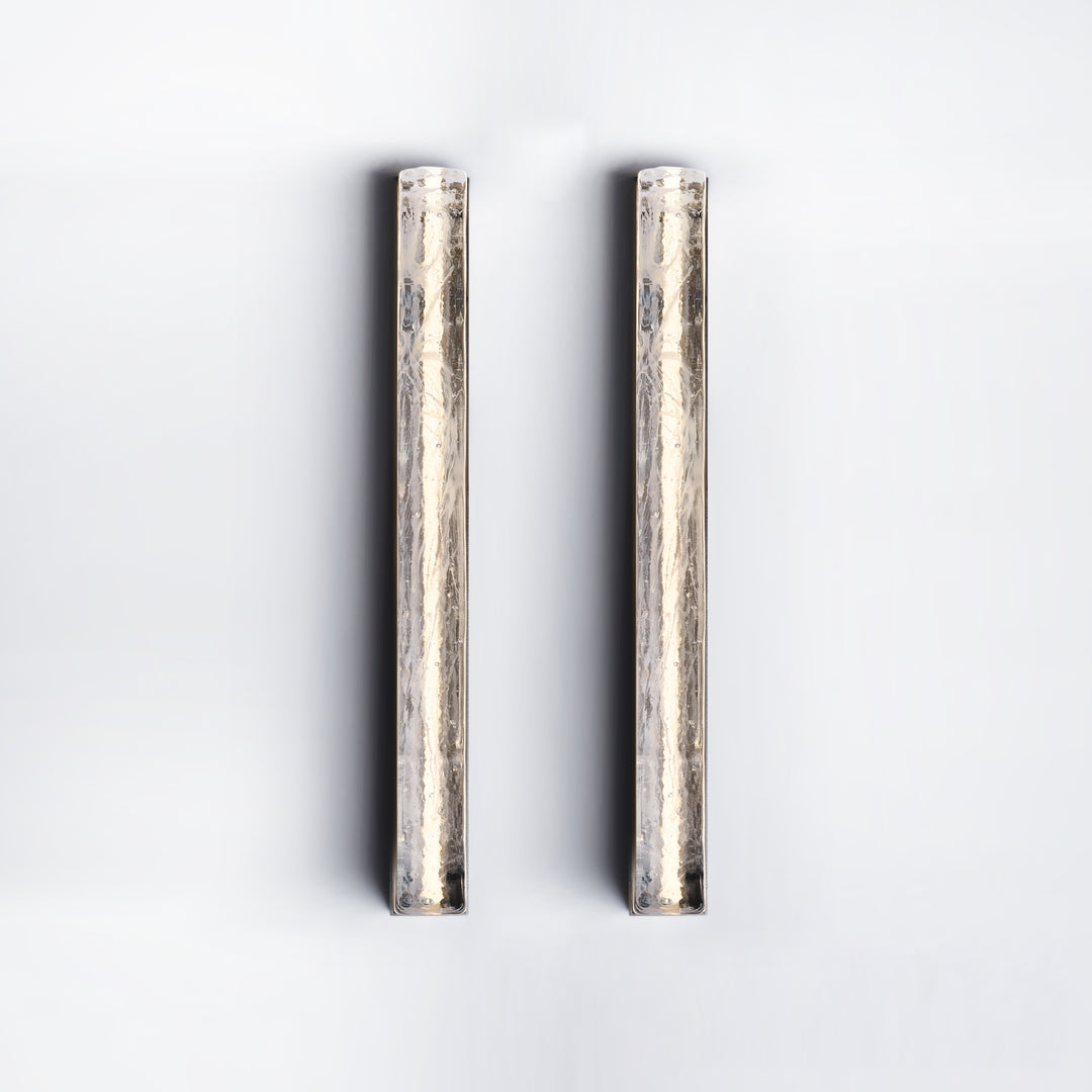 Running Water wall lamps in paired vertical arrangement providing warm ambient illumination ideal for modern interiors and decorative wall lighting.