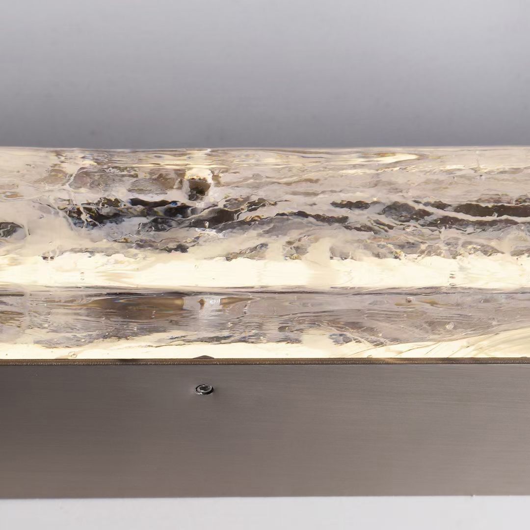 Running Water wall lamp with slim vertical European glass form offering soft ambient lighting for hallways voids and contemporary interior spaces.