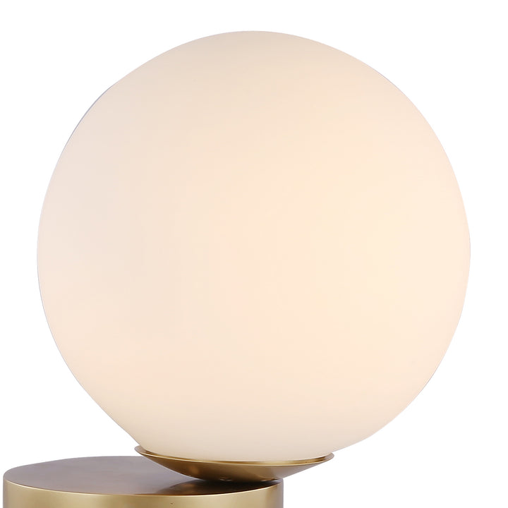 Opal glass orb table lamp with brass base providing soft warm illumination for modern Australian home decor.