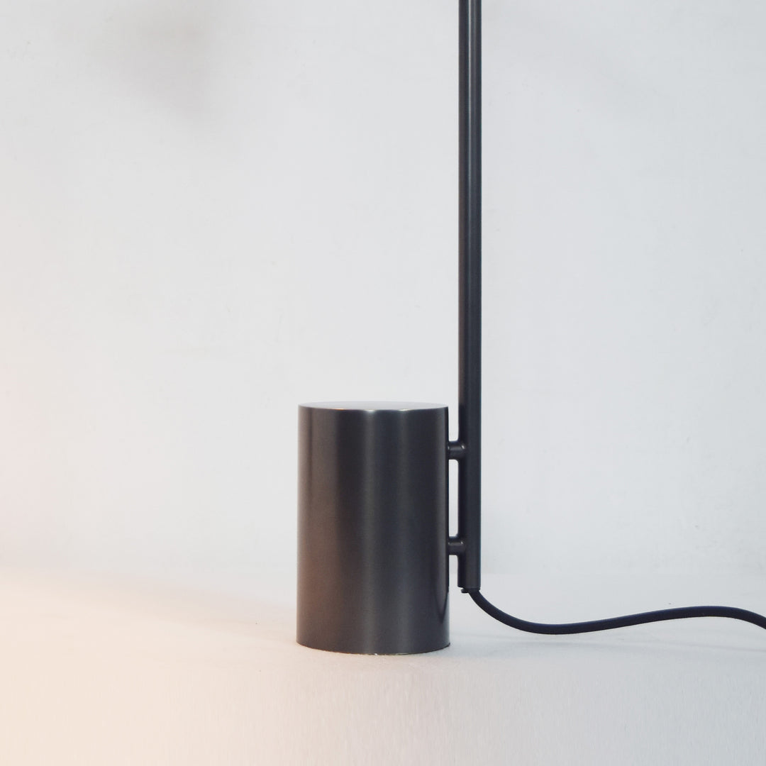Detail of sleek cylindrical base on modern black table lamp offering stable structure and refined minimalist styling.