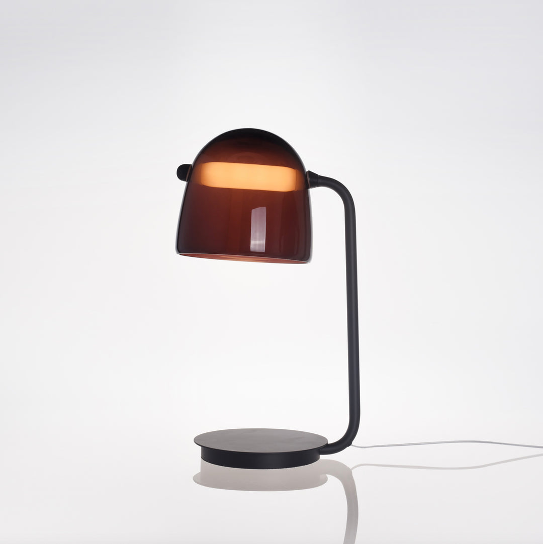 Swing Table Lamp with amber tinted glass shade and curved black metal arm ideal for modern bedside tables, desks and warm ambient lighting.