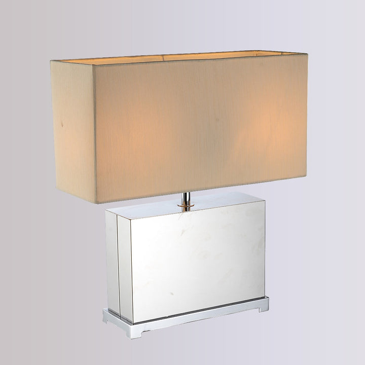 Tellman Table Lamp with rectangular fabric shade and polished metal base providing warm ambient lighting for bedrooms, living rooms and hotel-style interiors.