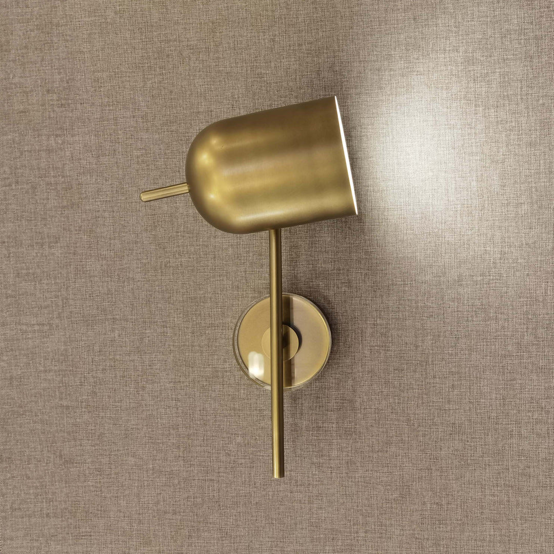 adjustable brass wall light on interior bedroom wall ideal for reading bedside wall lamp and soft ambient indoor wall lighting